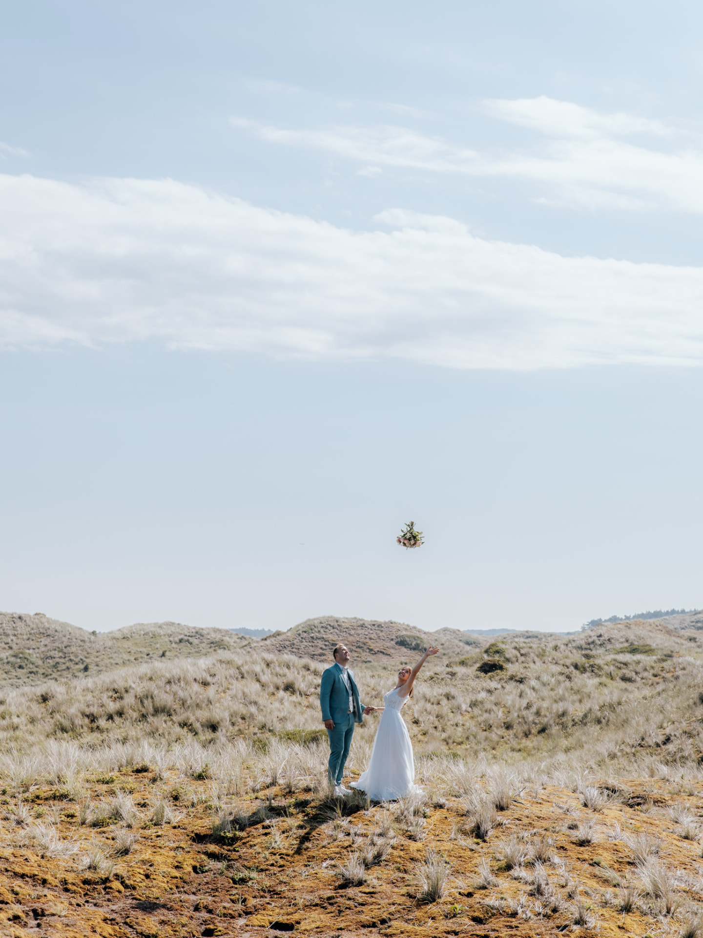 Hochzeitspaar in den Dünen wirft den Brautstrauß — Instagram-Beitrag