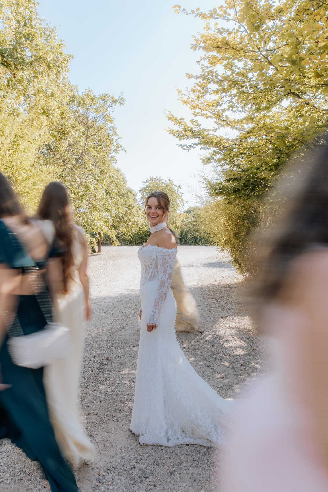 Braut blickt lächelnd zurück, Gäste in Bewegung — Hochzeitsfotografie NRW